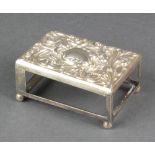 A Victorian repousse silver match box holder with floral decoration and vacant cartouche on ball