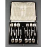 A cased set of 12 silver coffee spoons and nips with fancy handles and engraved monogram, London