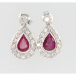 A pair of 18ct white gold ruby and diamond pear shaped earrings, the ruby approx. 1.6ct surrounded