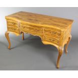 A Maples & Co olive wood dressing table/writing desk of serpentine outline with quarter veneered