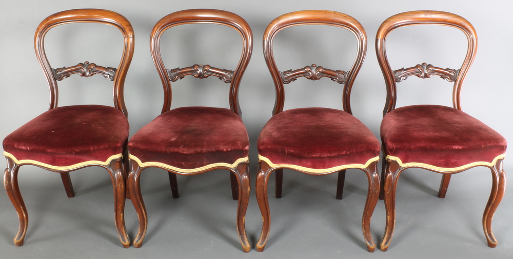 A set of 4 Victorian mahogany balloon back dining chairs with carved shaped mid rails, the seats
