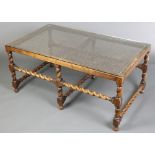 A 17th Century style rectangular oak occasional table with plate glass top, raised on spiral