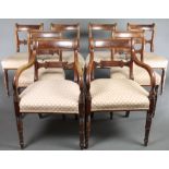 A set of 8 Regency bar back dining chairs with shaped mid rails and upholstered seats, raised on