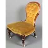 A Victorian mahogany show frame nursing chair upholstered in gold buttoned dralon, the seat of