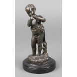 A 19th Century bronze figure of a standing child with flute, raised on a wooden socle base 6" (