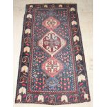 A Persian Qashqai rug with 3 diamonds to the centre 115" x 63", in wear