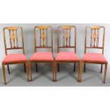 A set of 4 Edwardian inlaid mahogany stick and rail back dining chairs with upholstered drop in