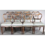 A set of 8 Victorian rosewood buckle back dining chairs with shaped mid rails and over stuffed