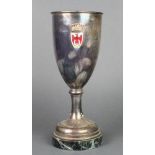 A silver plated presentation cup with enamelled badge on a green marble socle 12"