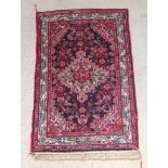 A blue and red ground Persian rug with central medallion 64" x 42" The fringe is missing from one