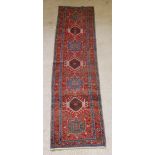 A tan and blue ground Heriz runner with 7 stylised medallions to the centre 127" x 35", in wear