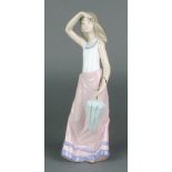 A Nao figure of a young lady holding a parasol 12"