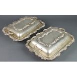 A pair of silver plated entree dishes with scroll decoration 12"