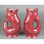 A pair of Dartmouth red glazed gurgle jugs in the form of fish 9"