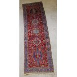 A Heriz Persian runner 121" x 37", in wear and missing fringing to 1 edge