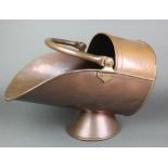 A Victorian copper helmet shaped coal scuttle