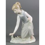 A Lladro figure of a kneeling girl picking flowers 8" Some of the petals are chipped