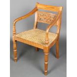 A Regency style mahogany bar back carver chair with pierced mid rail and woven cane seat, raised