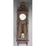 A Vienna style regulator with 7" dial and Roman numerals contained in a carved oak case