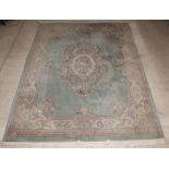 A green ground and floral patterned Chinese carpet 150" x 108", some light staining