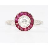 An 18ct white gold ruby and diamond target shaped ring, size O