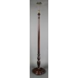 An Edwardian turned and fluted mahogany standard lamp raised on a turned base