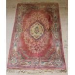 A pink and floral patterned Chinese carpet with central medallion 109" x 70", some staining