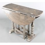 A 17th Century style oval oak drop flap gateleg tea table, raised on bobbin turned supports 22 1/2"h