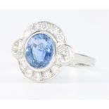 An 18ct white gold oval sapphire and diamond cluster ring, the centre stone approx. 2ct surrounded