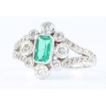 An 18ct white gold emerald and diamond cluster ring, the centre emerald approx 0.5ct, size M