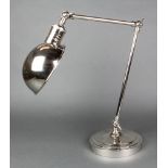 A plated student's adjustable table lamp on a circular base