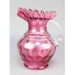 A Victorian cranberry ware jug with clear fluted glass handle 9"