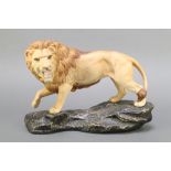 A Beswick matt glazed figure of a standing lion on a rocky outcrop 8 1/2"