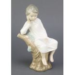 A Lladro figure of a child sitting on a tree stump A/125 8", boxedThis lot is in good condition.