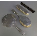 A silver engine turned brush set with floral decoration comprising hand mirror, clothes brush,