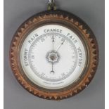 An aneroid barometer contained in a carved oak case