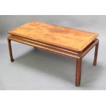 A Chinese style rectangular mahogany coffee table with quarter veneered top, raised on shaped