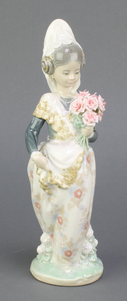 A Lladro figure of a Spanish lady holding a bouquet of flowers 9 1/2", boxedSome of the petals are