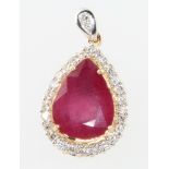 A yellow gold pear shaped ruby (treated) and diamond pendant, the pear shaped stone surrounded by 26