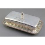 A rectangular silver plated butter dish with glass liner and inscription