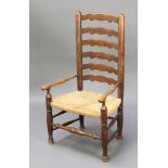 An elm Lancashire ladder back chair with woven rush seat, raised on turned supports