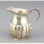 An Edwardian silver cream jug with demi-fluted decoration Chester 1903, 64 grams 3"