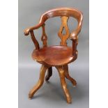 A 19th Century mahogany tub back revolving office chair with pierced slat back raised on scrolled