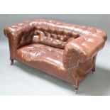 A 2 seat drop arm Chesterfield upholstered in brown buttoned leather, raised on cabriole supports