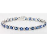 An 18ct white gold sapphire and diamond line bracelet, the oval cut sapphires 11.3ct interspersed