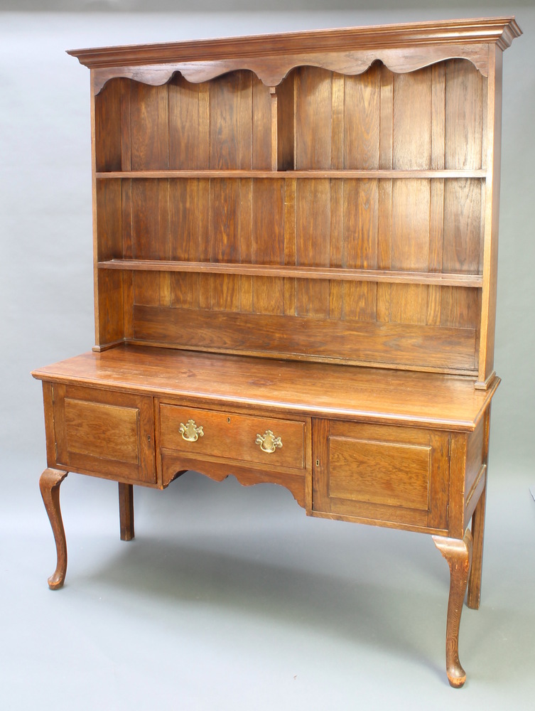 A Georgian style oak dresser the raised back with moulded cornice, shaped apron and fitted 2