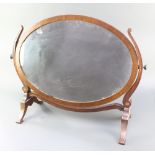 An oval plate dressing table mirror contained in a mahogany swing frame 23"h x 29"w The left horn