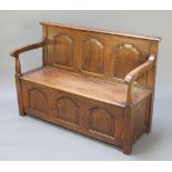 An oak settle with arcaded panelled decoration and hinged lid to the seat, 37 1/2"h x 54"w x 20"d