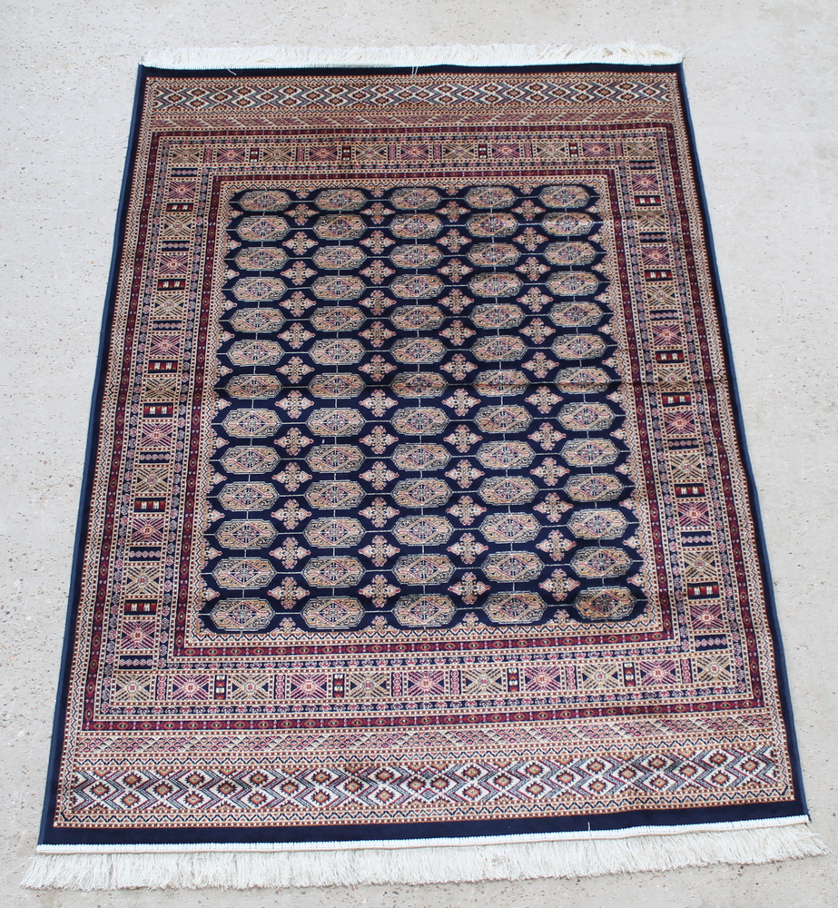 A blue and gold ground Bokhara style Belgian cotton rug with numerous octagons to the centre 76" x