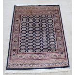 A blue and gold ground Bokhara style Belgian cotton rug with numerous octagons to the centre 76" x